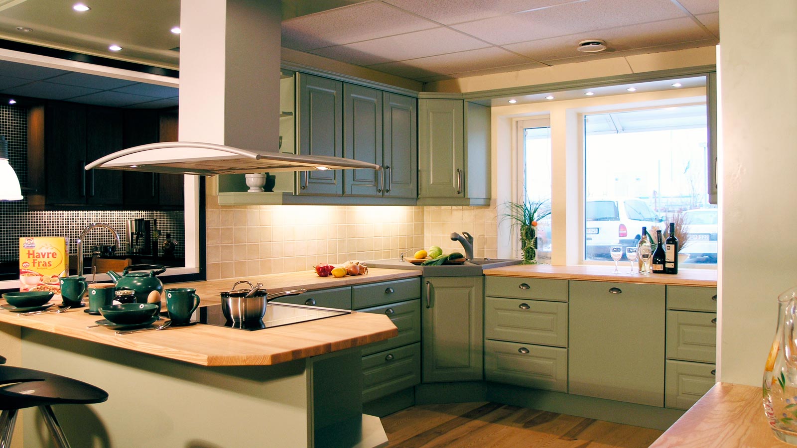 Köksluckor från Smartkök. Exempelbild på ett kök med köksluckor i klassisk stil tillverkade i massivt trä. Luckorna är gröna och bänkskivan är i ljust trä.